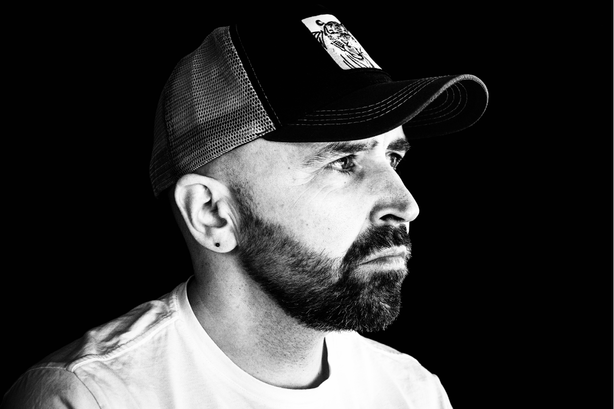 Black and white image of Willie Campbell in trucker cap looking to side